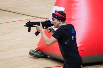 Игрок LASERWAR в красном обруче целится из оружия